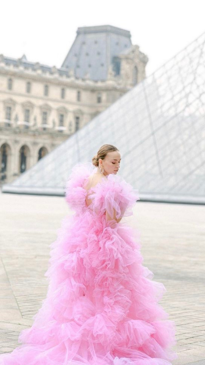 Bride in pink iconic wedding dress at the Lourve, paris